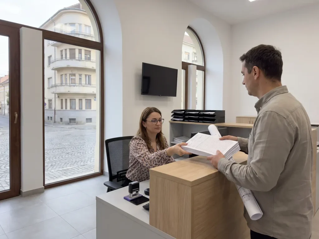 Solicitant care depune la ghișeul de urbanism al unei primării dosarul cu formularele tipizate de autorizare a construirii