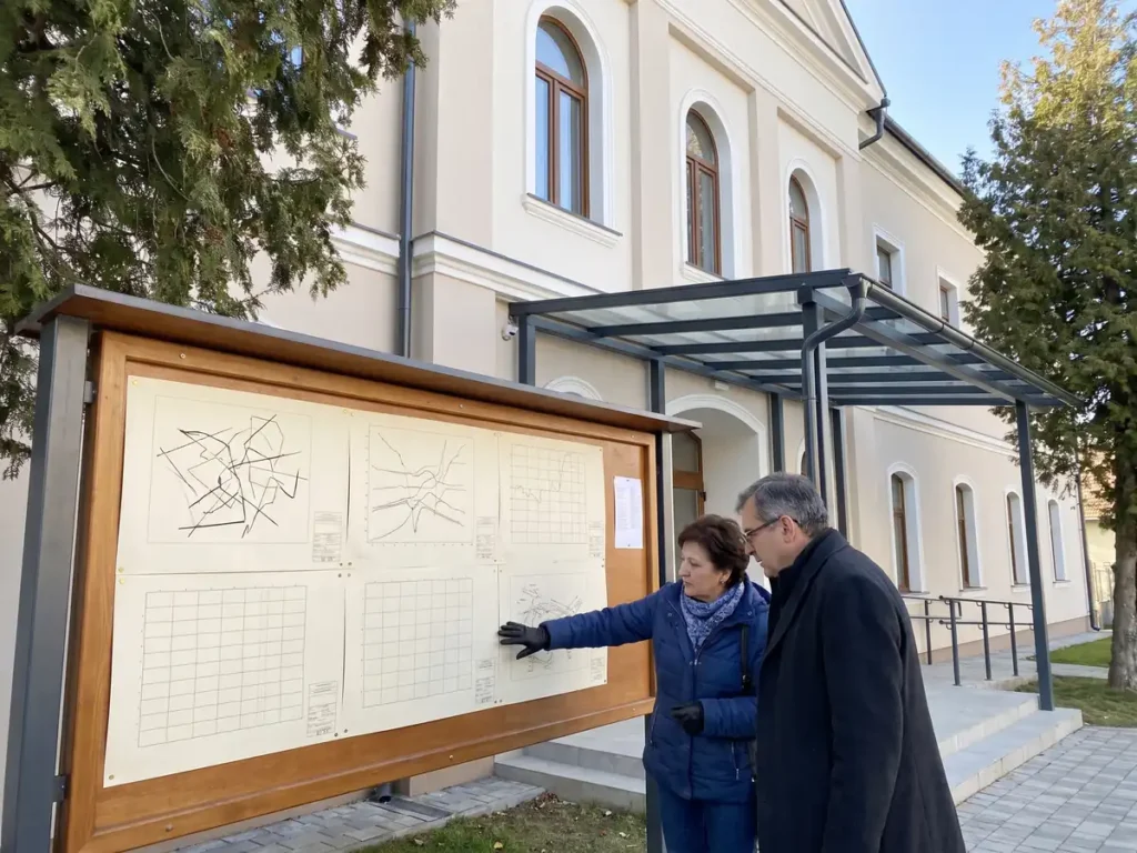Doi cetățeni studiază planurile cadastrale afișate la avizierul unei primării din România, ilustrare pentru Decizia CCR nr. 735/2025 privind rectificarea documentelor tehnice de cadastru