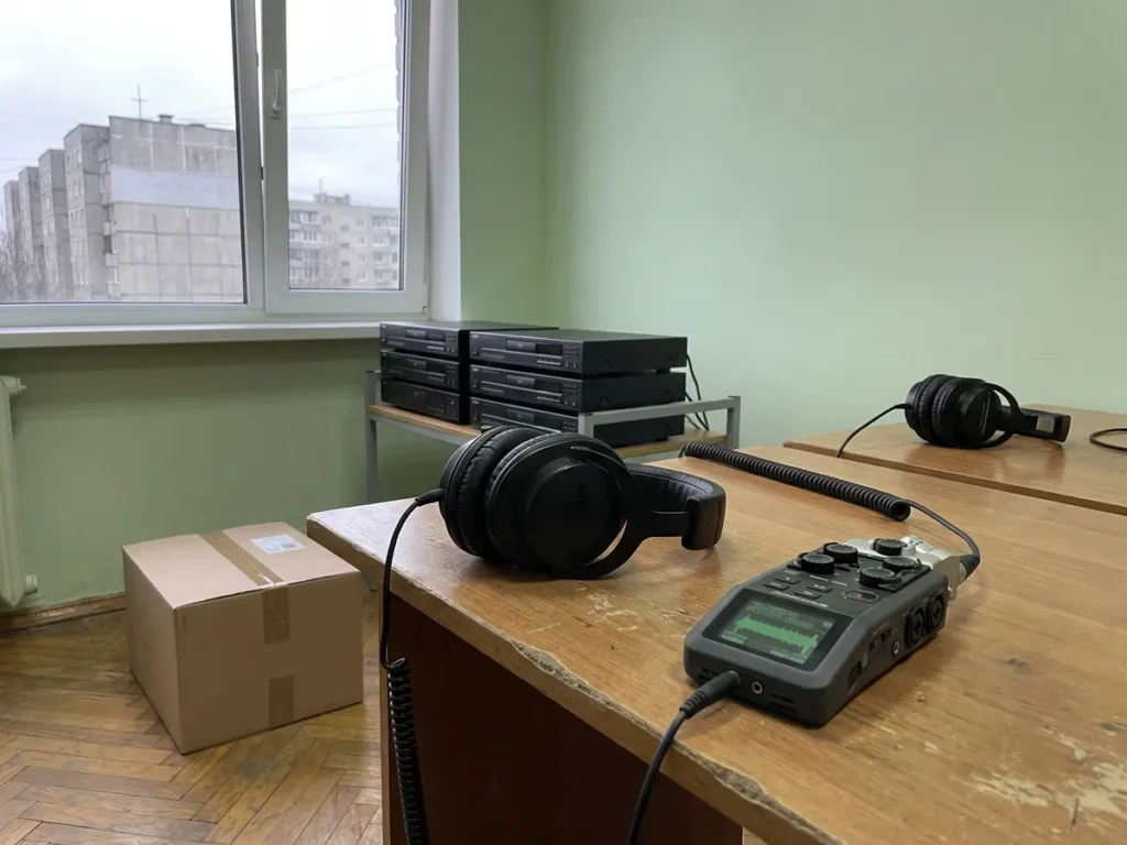 Căști profesionale și un reportofon digital pe un birou, într-o cameră de ascultare a înregistrărilor din supravegherea tehnică